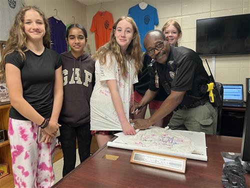 SRO officer signing t-shirt with magic marker